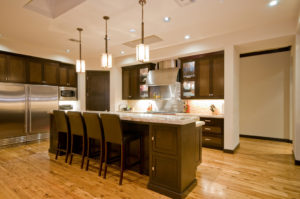 A kitchen with wooden floors and dark cabinets.