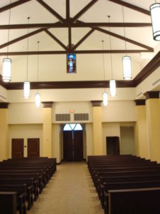A church with pews and lights in the ceiling.